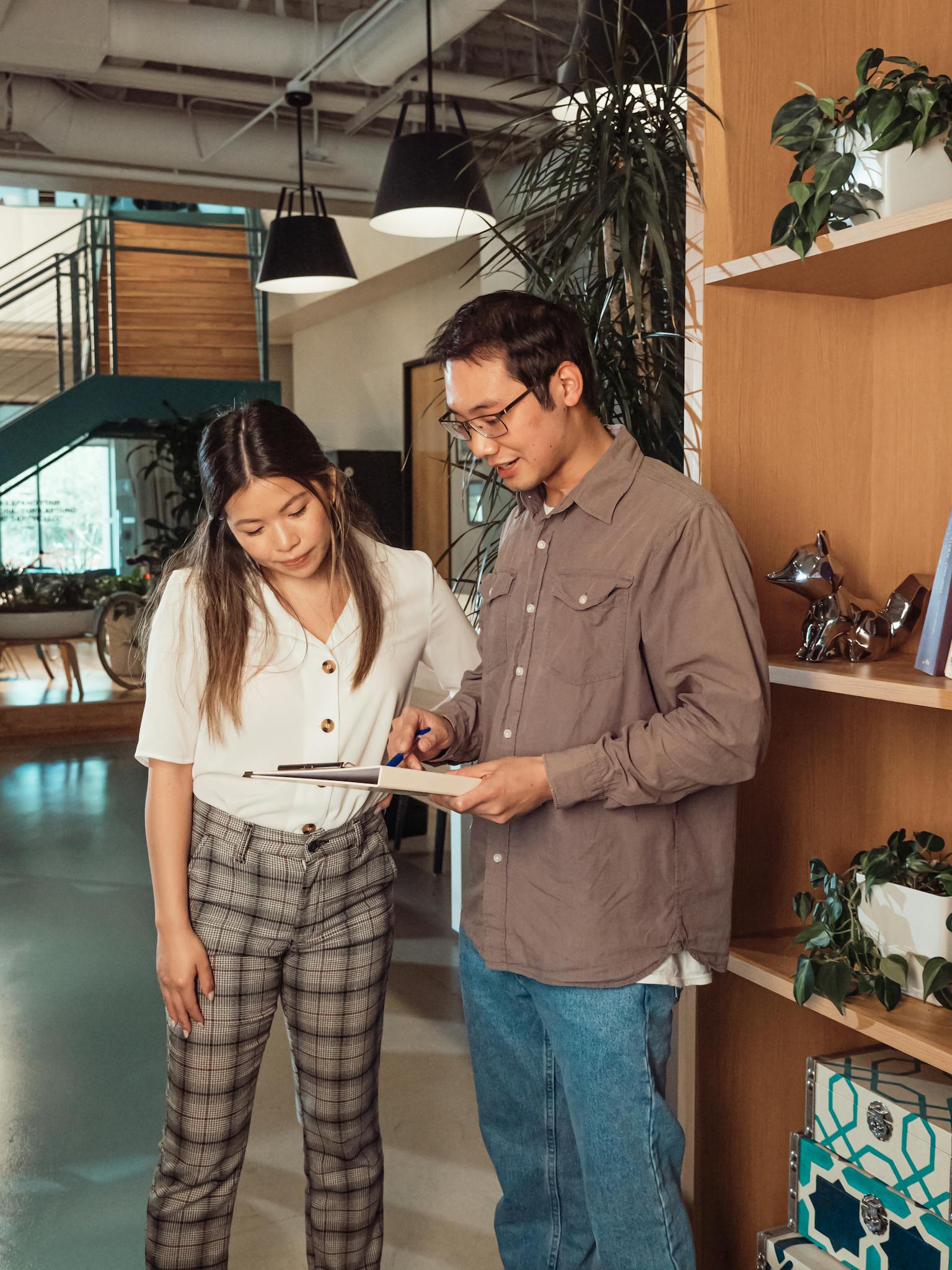 Two colleagues engage in a collaborative discussion in a stylish, modern office environment.